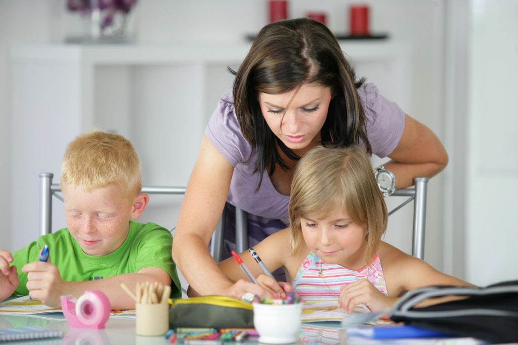 Mom teaching two kids, homeschooling, mom teaching kids